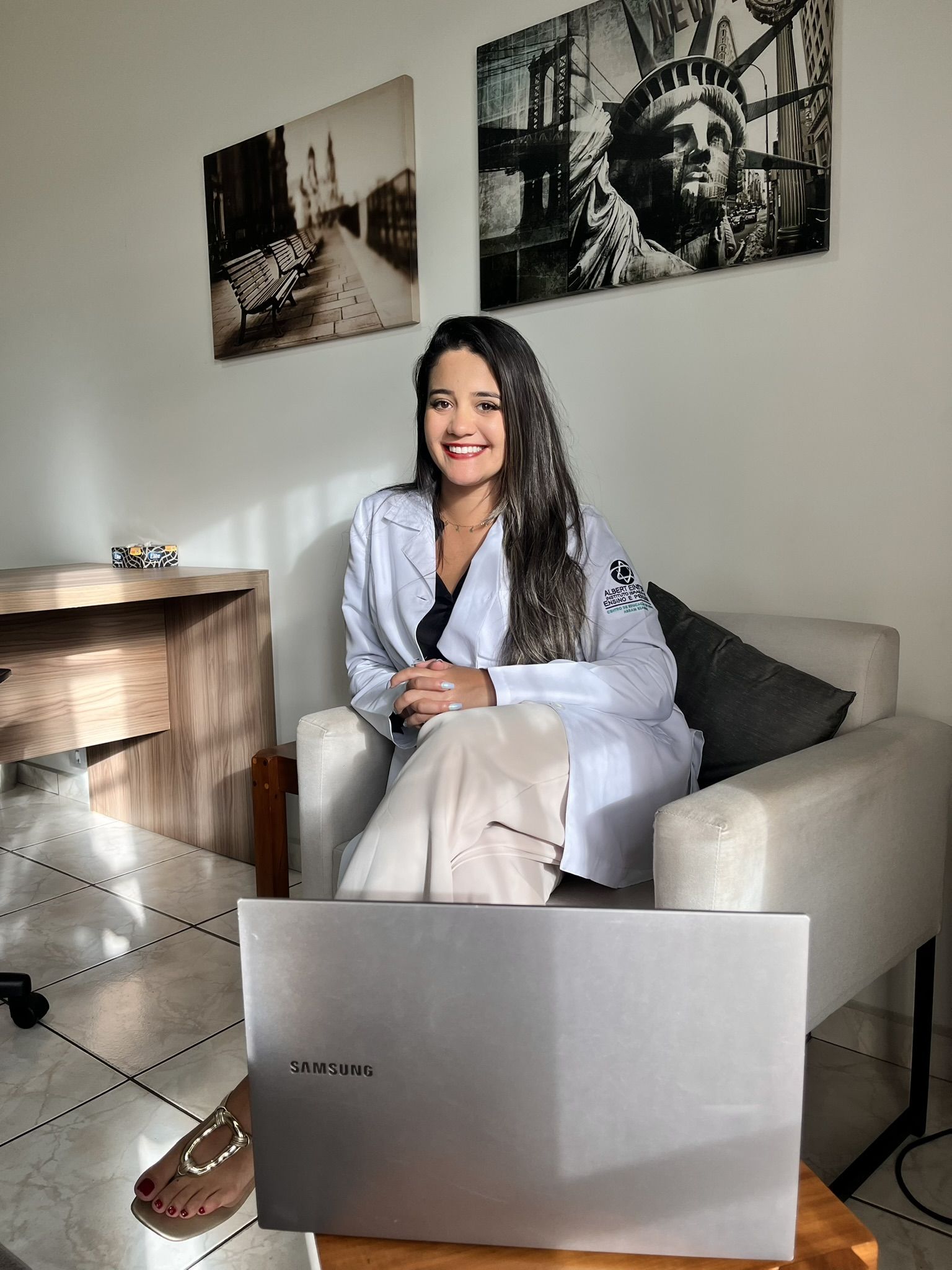 Dra. Échilen Rodrigues em seu consultório, sentada em uma poltrona.